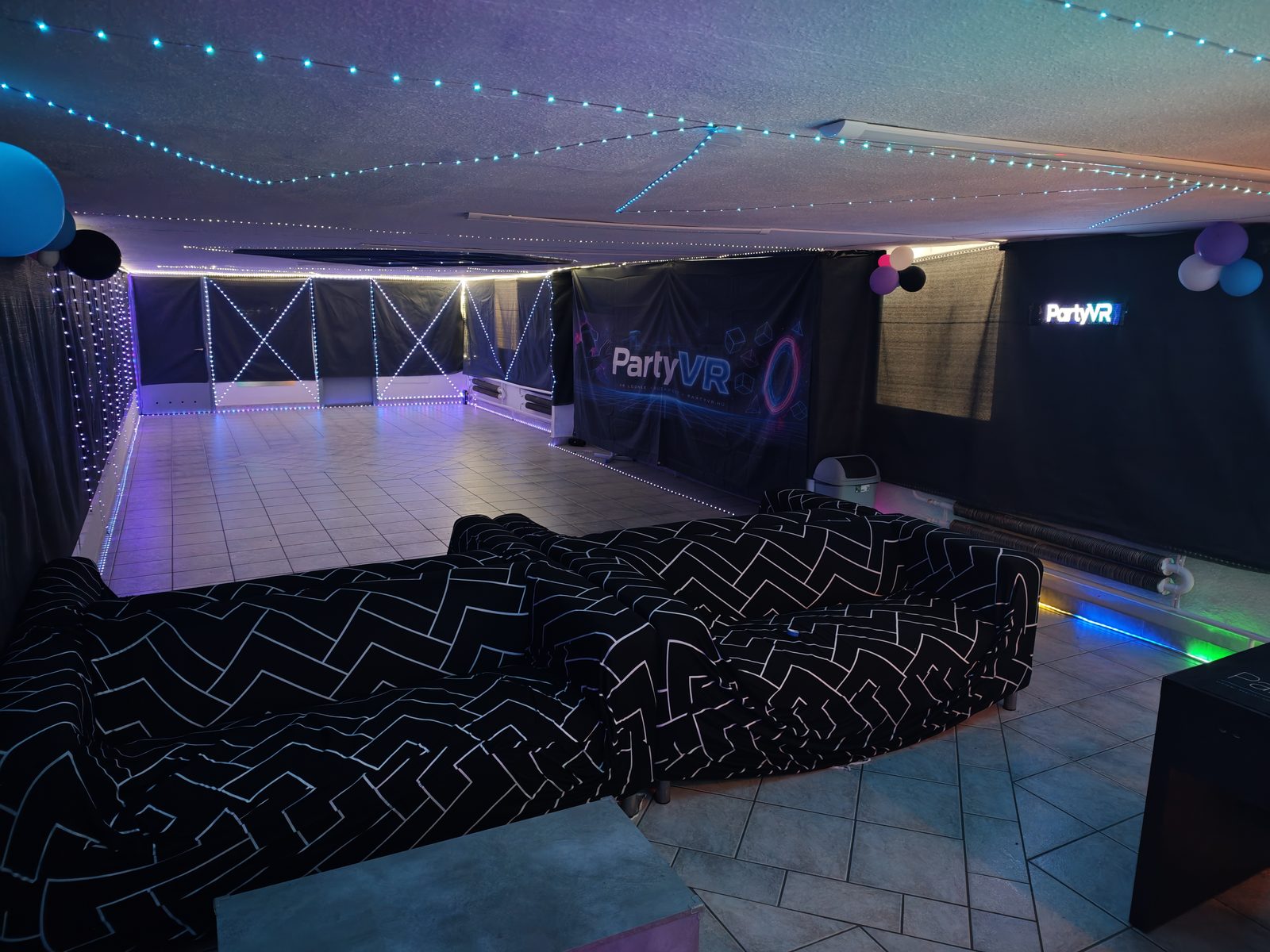 PartyVR play area side view with neon edge lighting and padded floor